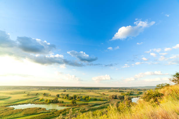 istock A beautiful valley with a river, blue sky with large clouds and bright sun. Aerial 4K UHD 1287882403