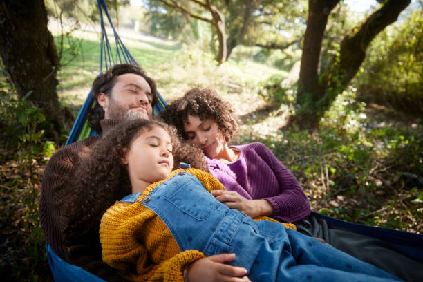 istock Family sleeping together on a hammock in the woods 1287882974