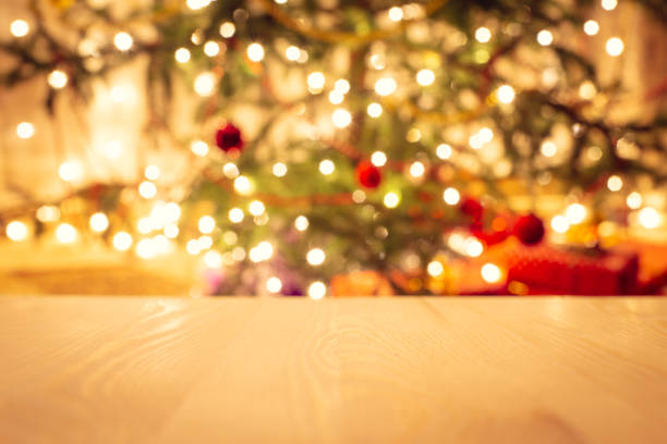 istock Empty wooden table with decorated christmas tree on the background. 1287884031
