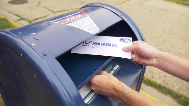 Man Puts Mail In Ballot in Mail Box