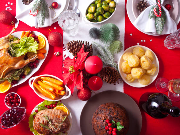 istock Table served for thanksgiving or Christmas dinner. Stuffed roasted turkey, pudding and ham. Traditional celebrating holiday. Top view. 1287884395