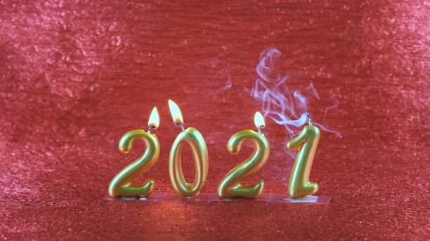 istock Extinct gold New Year's candles 2021 on red background. modern concept 1287884794
