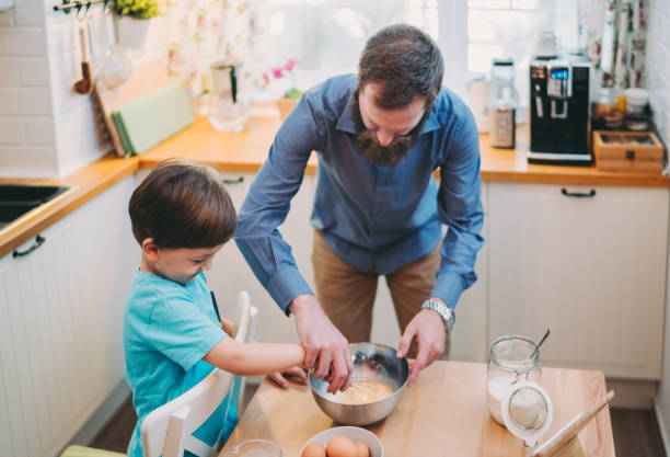 istock Little boy preparing pancake batter with his father 1287886590