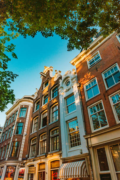 Grachten Canal Houses at Street Kloveniersburgwal, Amsterdam, Netherlands August 1st, 2020 – Amsterdam, Netherlands: Amsterdam is very popular and world-known for its beautiful architecture around the canals and water ways walking point of view stock pictures, royalty-free photos & images