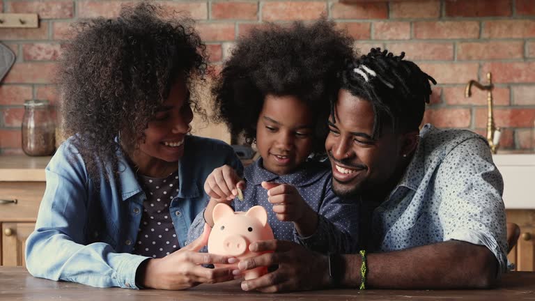 African family save money putting coins in piggy bank