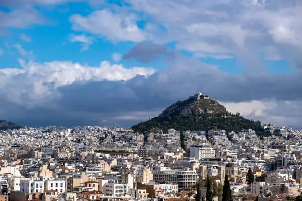 Mount Lycabettus and Athens cityscape view from Acropolis hill in Greece, blue cloudy sky, sunny day