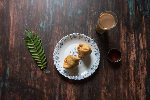istock Top view of  Indian snack samosa and tea along with condiments 1287894174