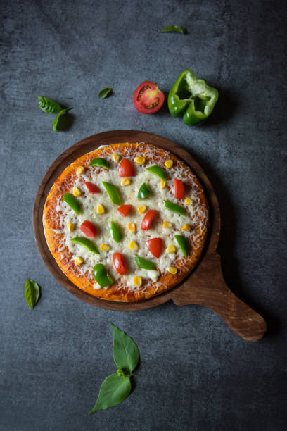 Vertical top view of margherita pizza with vegetables and herbs