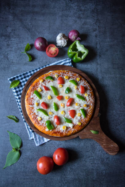 vista vertical da pizza de iguaria popular com tomates e mussarela - adulation asia cooked food - fotografias e filmes do acervo