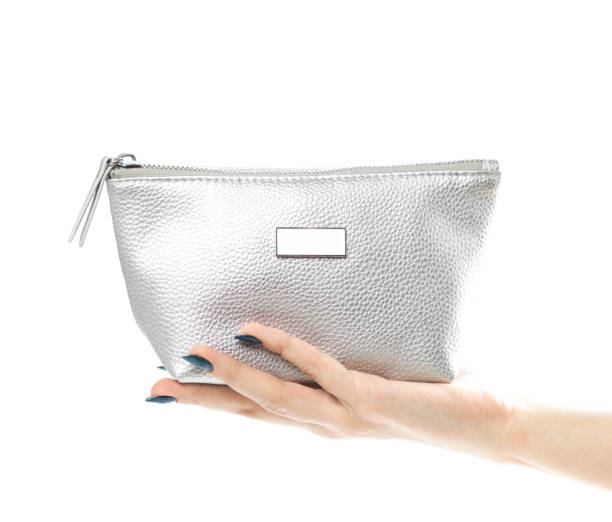 istock Hand holding a small silver purse. Close up. Isolated on a white background 1287897867