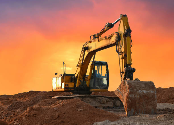 istock Excavator working on earthmoving at open pit mining on amazing sunset background 1287899774