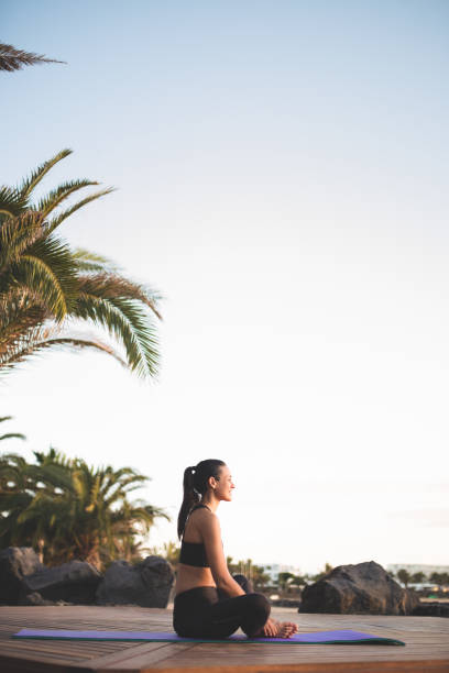 istock Young beautiful woman meditating outdoors at sunrise. 1287902812