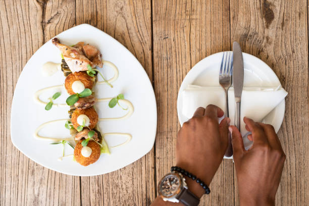 istock Chicken kebab on table with African hands picking up cutlery 1287903246