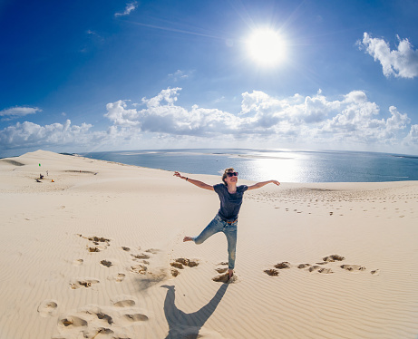 Young woman enjoying herself in the dune of Pilat, Aquitaine, France