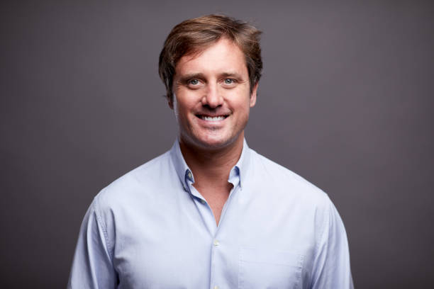 istock One smiling businessman on a plain button-down shirt. 1287906582