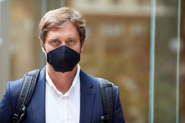 istock Business man with a protective facemask standing on the street. 1287906669