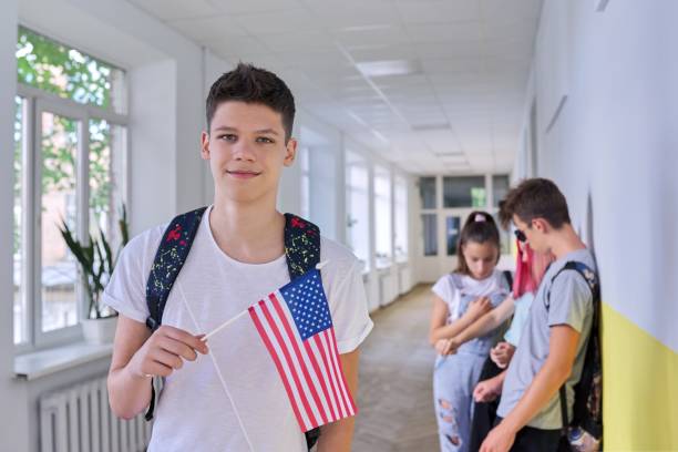 mężczyzna student nastolatek z flagą usa wewnątrz uczelni, grupa studentów tle - adolescence flag university people zdjęcia i obrazy z banku zdjęć