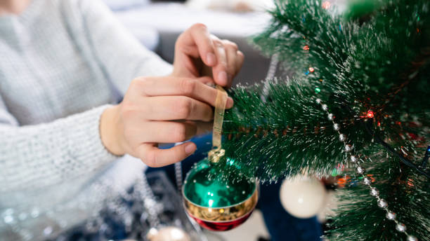 istock Closeup of woman decorating Christmas tree 1287909117