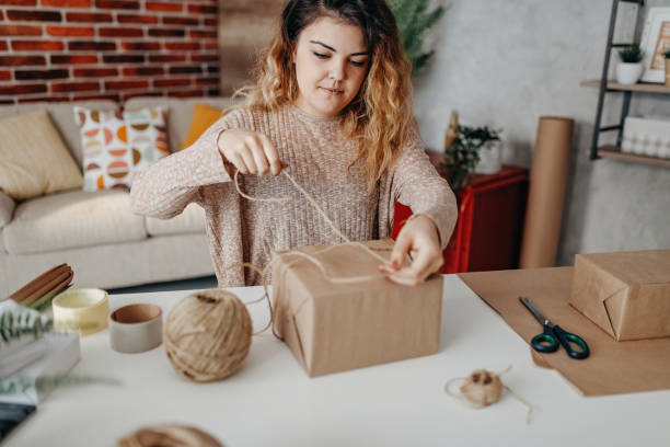 istock The young woman wrapped the box in paper 1287909802