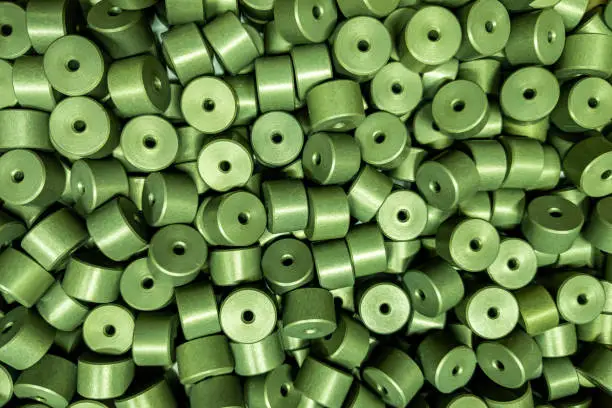 Photo of full frame batch of aluminium cylinder parts after anodizing with filling in green chromate solutions