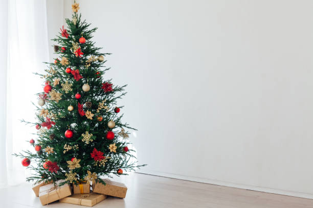 istock christmas tree with colorful balls and gift boxes over white wall 1287921501