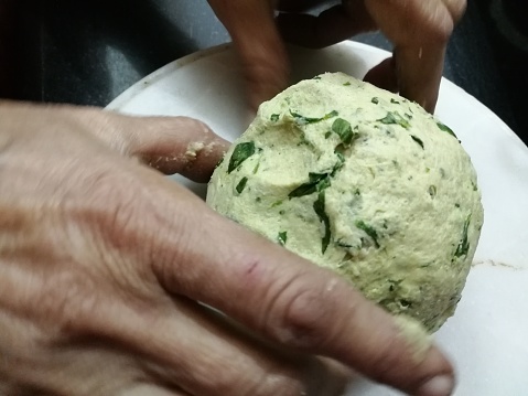 kneading wheat dough stuffed with fenugreek green leaves during winter season, home made