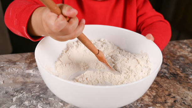 istock Child kneads flour with a spoon 1287922968