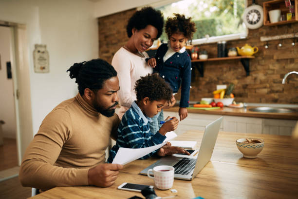istock African American man trying to work on a computer while being with his family at home. 1287923524