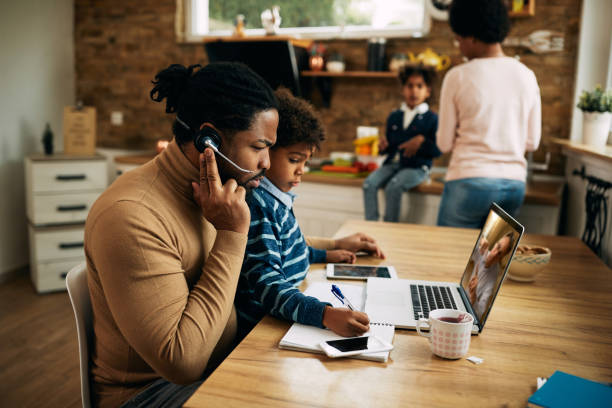 istock Black working father making a conference call while son is sitting in his lap at home 1287923553