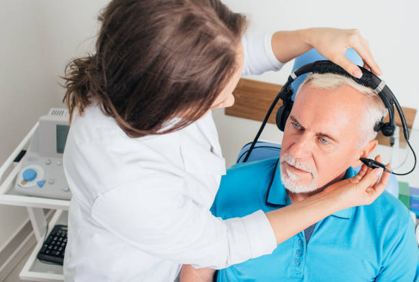 Senior man having hearing exam at audiologists office audiologist doing hearing test to a mature man at hearing clinic hearing test stock pictures, royalty-free photos & images