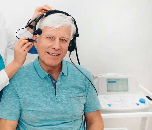 Photo of Impedance audiometry, diagnosis of hearing impairment. An elderly man getting an auditory test in a hearing clinic, close up.