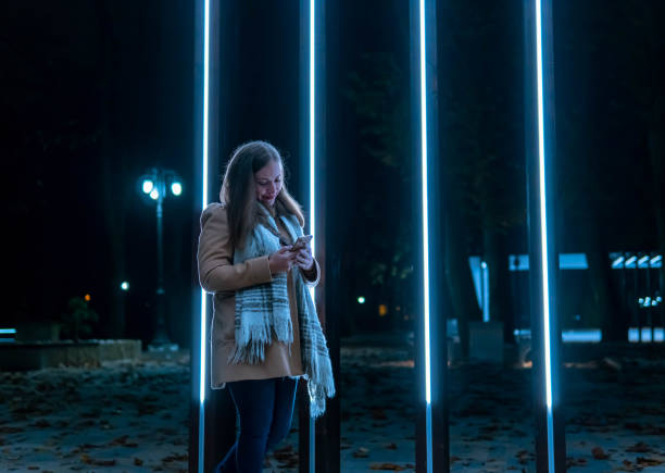 istock Young Woman Using Mobile Phone on Night Out in the City. 1287932944