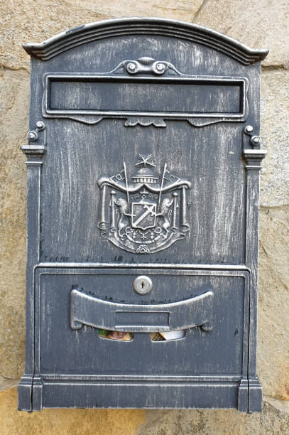istock black metal mailbox with patterns. The mailbox is hanging on the wall 1287935945
