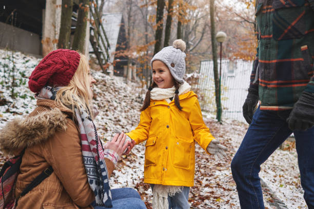 istock Caring mother putting gloves on her daughter hands, so she can be warm while playing in the snow 1287936923