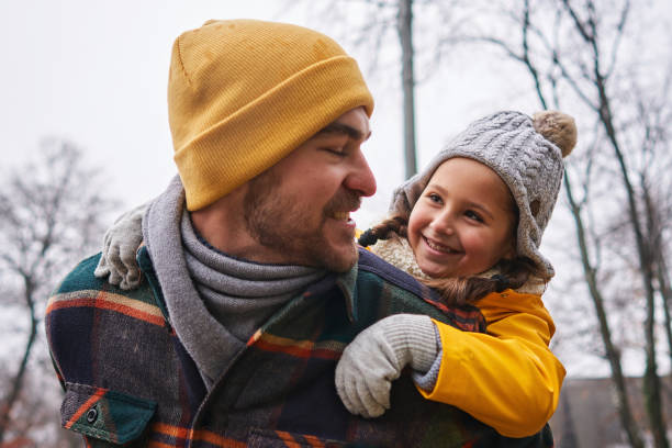 istock Grateful daughter can't hide her happiness while enjoying a piggyback ride with her father during winter walk 1287937278