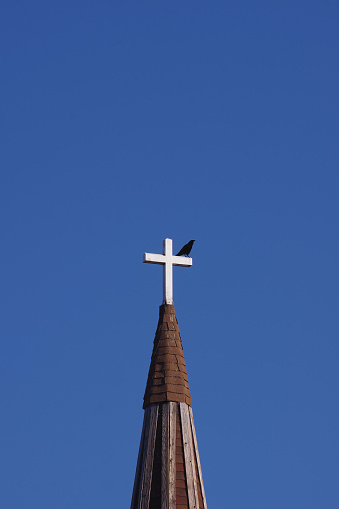 Cross and spires of Congregational Church, Panmure Street, Dundee, Scotland, against blue sky and clouds