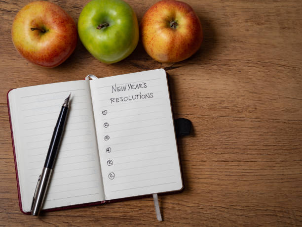 istock Notebook with New Year's resolutions surrounded by apples and a fountain pen 1287941175
