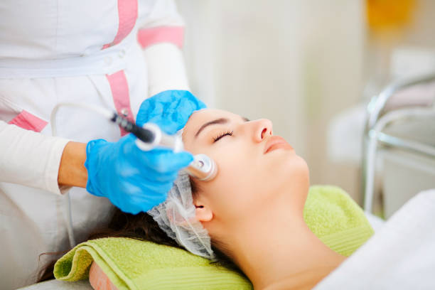 The cosmetologist makes the procedure Microdermabrasion of the facial skin of a beautiful, young woman in a beauty salon Facial Mask - Beauty Product, Microdermabrasion, Beauty Treatment, Healthcare And Medicine, Design microdermabrasion stock pictures, royalty-free photos & images