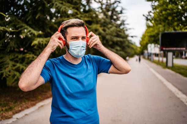 istock Man putting headphones on before running 1287943208