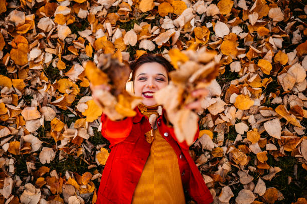 istock Woman lying on autumn leaves 1287945908