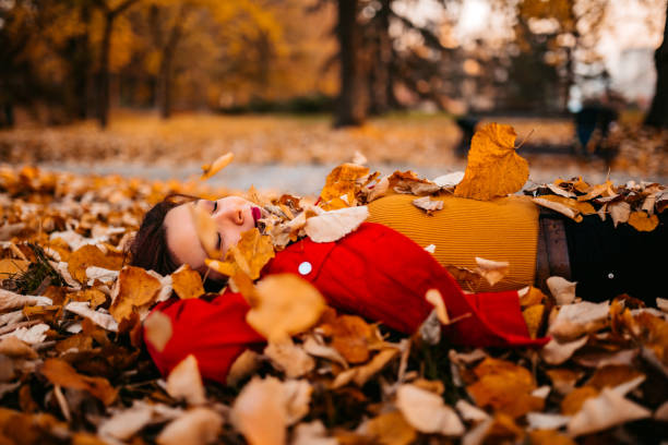 istock Woman lying on autumn leaves and dreaming 1287945976