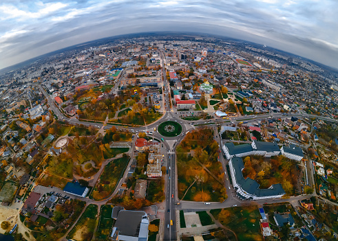 Aerial panoramic view of roundabout road with circular cars in small european city at cloudy autumn day, Kyiv region, Ukraine