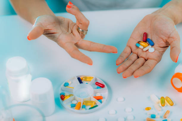 istock Prescribed medication non-adherence. Female patient counting pills. 1287947868