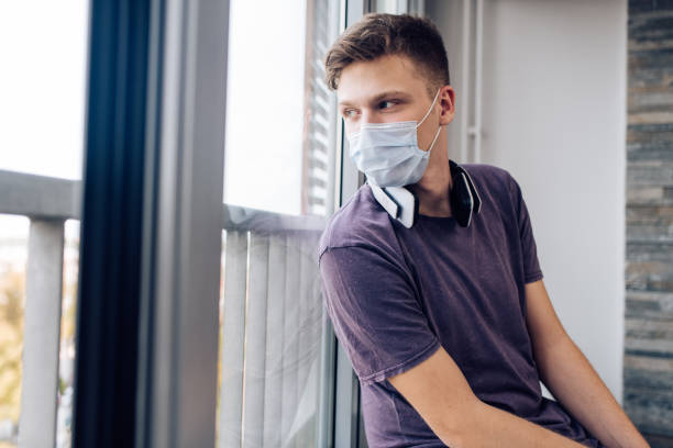 istock Young man with a face mask feeling depressed due to Covid 19 virus 1287950083