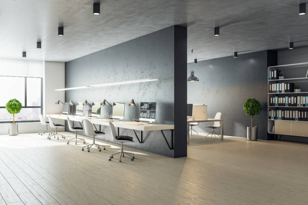 istock Modern coworking office interior with long desk, computers, chair and city view. 1287953666