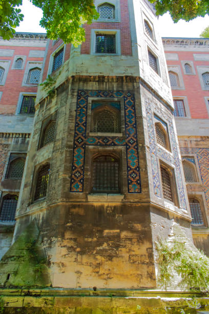 istock Large historic building covered with tiles. building with large windows and decorated with colorful motifs around it. Historic building with old worn ornaments. 1287954611
