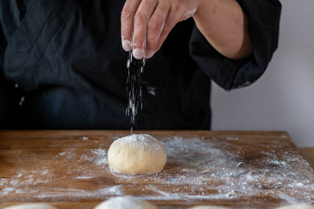 istock Woman chef pouring flour on dough 1287956710