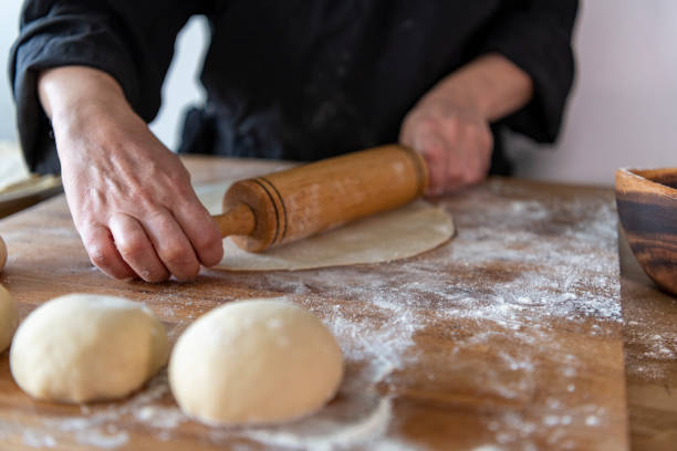 istock Hands baking dough with rolling pin on wooden table 1287956954