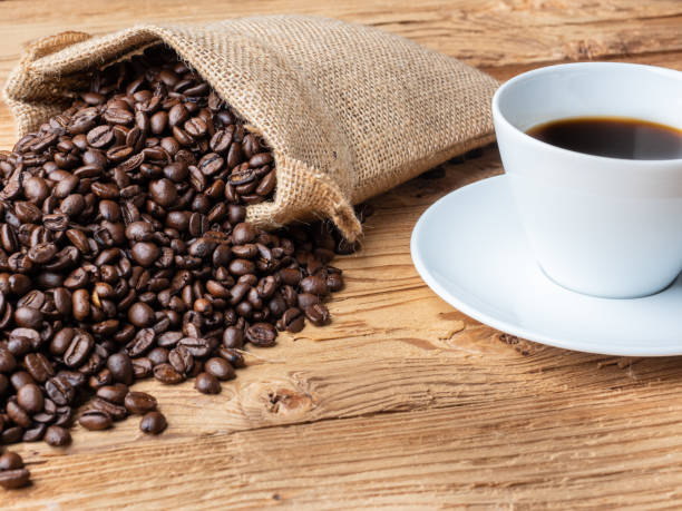 istock Coffee beans and freshly brewed coffee on black background 1287958542