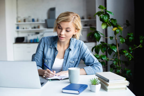 istock young blonde woman studying online and making notes 1287961112